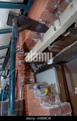 ACROW PROPS WITH STRONG BOYS HOLDING A SUPPORTING WALL BEFORE A RSJ IS FITTED TO ALLOW THE ENLARGEMENT OF A WALL OPENING Stock Photo