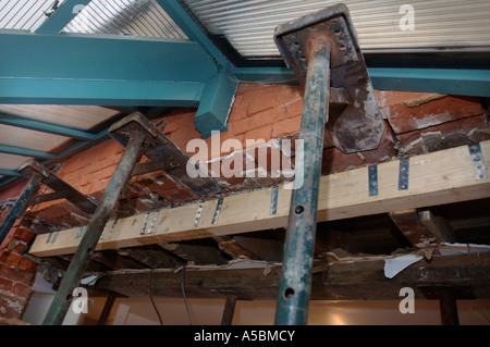 ACROW PROPS WITH STRONG BOYS HOLDING A SUPPORTING WALL BEFORE A RSJ IS FITTED TO ALLOW THE ENLARGEMENT OF A WALL OPENING Stock Photo