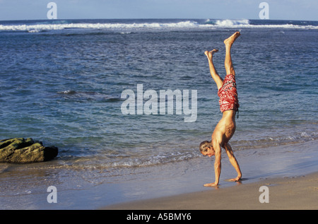 Man doing handstand on beach Kauai Hawaii Stock Photo