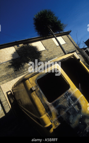 Empty home in Nunhead South London with palm trees and burnt out vehicle England Stock Photo