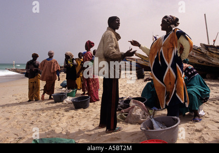 Mauritanian fisherman trading with women in traditional clothing on Nouakchott beach, Mauritania, Africa Stock Photo