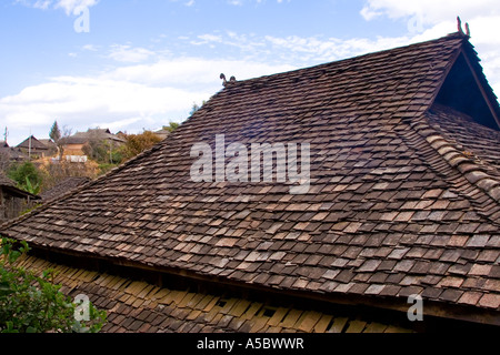 Smoke Passing through Shingles Traditional Akha Wooden Houses near Xiding Xishuangbanna China Stock Photo