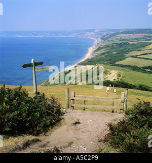 Walkers on the south coast long distance path near Golden Cap, Dorset, UK. Lyme Bay  and Lyme Regis beyond. Stock Photo