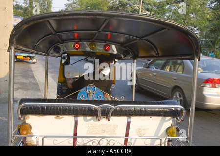 Smog protection in the  busy capital city Bankok.  Driver of Tuk-tuks taxi wearing pollution filter mask filtering  vehicle exhaust fumes. Stock Photo