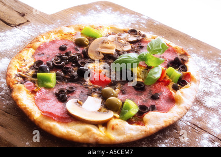 Fresh pizza on wooden cutting board, close-up Stock Photo