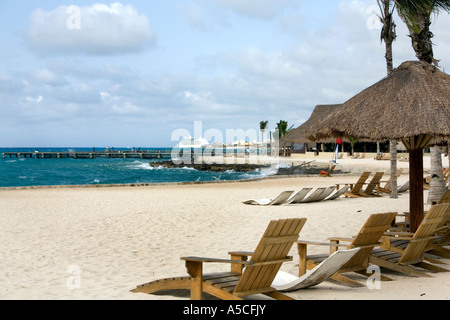 Sandy beach at Cozumel, Mexico with thatched umbrella tables for tourists Stock Photo