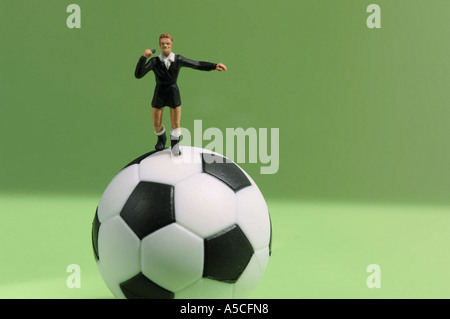 Referee figuring standing on football, close-up Stock Photo