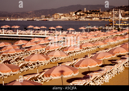 Cannes, France, Pink umbrellas and beach chairs along the French Riviera Stock Photo