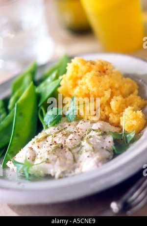 Poached fish with lime shreds and mixed ground pepper with mangetout peas and mashed swede Garnished with coriander Stock Photo