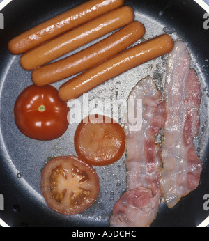 Sausages, tomatoes, and bacon in pan Stock Photo