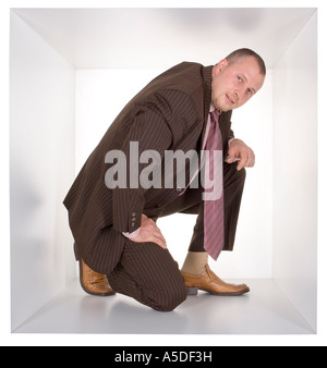 businessman in the cramped white cube Stock Photo