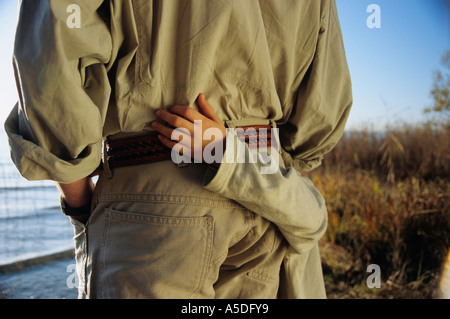 Father and son by lake, mid-section, rear view Stock Photo