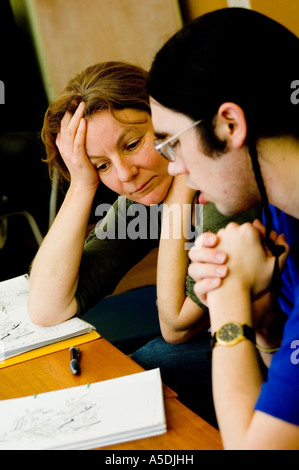 two young Adults  - man and woman - learning welsh language in evening class Aberystwyth university, Wales UK Stock Photo