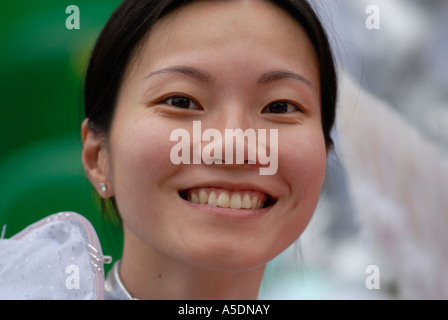 Young Chinese girl in festive outfit smiling during Chinese Lunar New Year celebrations in Kowloon, Hong Kong, China Stock Photo