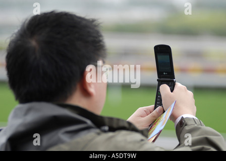Chinese man taking photos with cellular phone Stock Photo