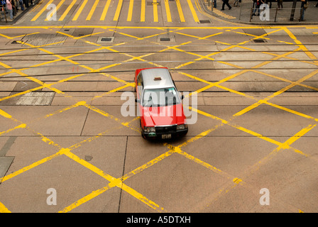 A red taxi car crossing tram railway in Hong Kong island China Stock Photo