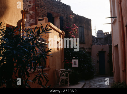 Collioure back streets A colour photo in afternoon light of flowers table and chair outside an artist s studio on a small lane Stock Photo