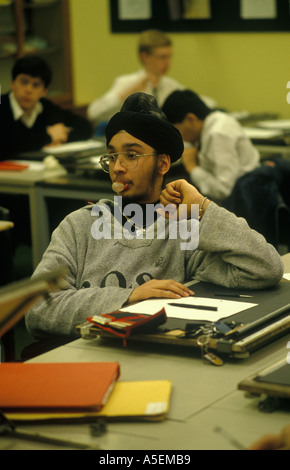 Asian 4th form male student blowing bubble gum in a class room lesson  Greenford High school Middlesex 1990s 1990 HOMER SYKES Stock Photo