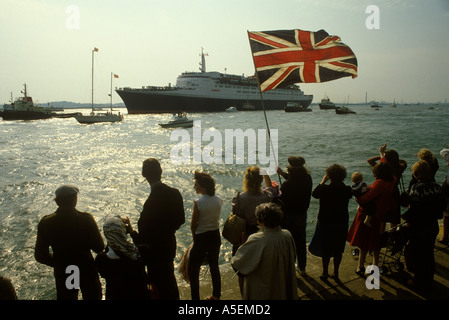 Falklands war Queen Elizabeth QE2 leaves Southampton dock for the Falklands Conflict, a flotilla of boats seeing her off May 1982 1980S UK Stock Photo
