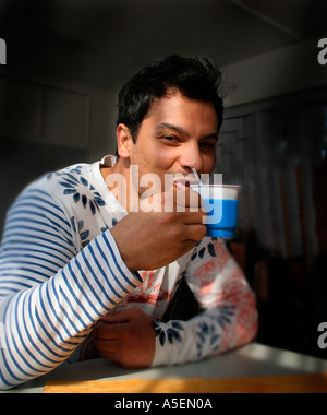 Man sipping coffee smiling Stock Photo