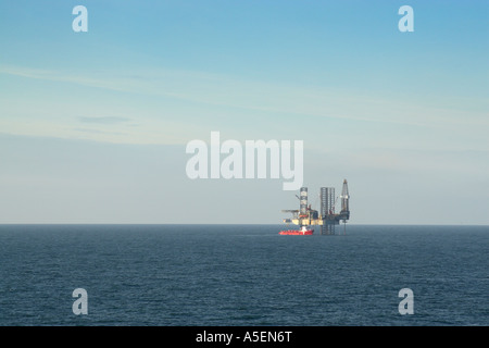 Ensco 80 drilling rig stationed in North Sea with supply vessel alongside drilling an exploration well Stock Photo