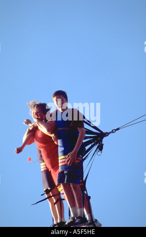 Mom and kids on bunji jump ride at state fair mom age 40 children age 14 and 16. St Paul Minnesota USA Stock Photo