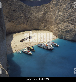 View down over spectacular Shipwreck Bay and steep cliffs with distant people on beach Zakynthos The Greek Islands Greece Stock Photo