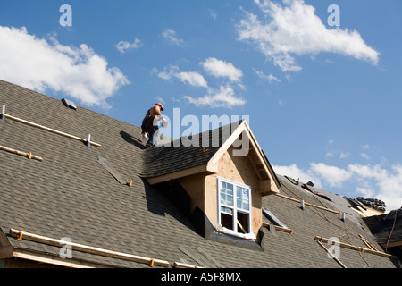 Immigrant Worker Installing Roof Shingles Stock Photo