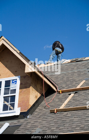 Immigrant Worker Installing Roof Shingles Stock Photo