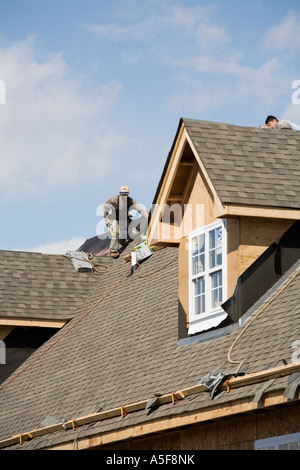 Immigrant Worker Installing Roof Shingles Stock Photo