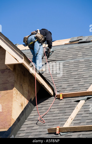 Immigrant Worker Installing Roof Shingles Stock Photo