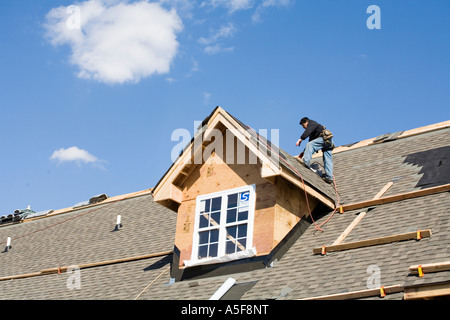 Immigrant Worker Installing Roof Shingles Stock Photo