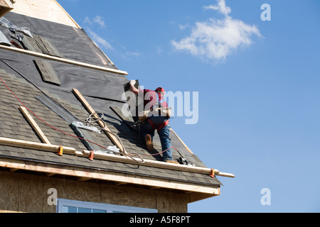 Immigrant Worker Installing Roof Shingles Stock Photo