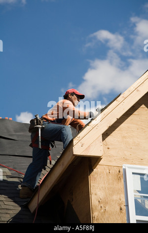 Immigrant Worker Installing Roof Shingles Stock Photo