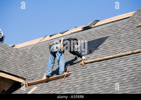 Immigrant Worker Installing Roof Shingles Stock Photo