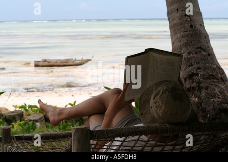 ZANZIBAR:  Relaxing and reading a book in front of a white sand beach on the east coast, Tanzania Stock Photo