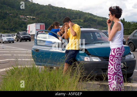 Brazilian man and woman using cell phones at the scene of a traffic accident near Sao Paulo Brazil Stock Photo