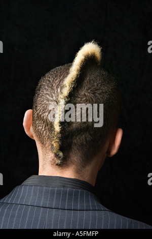 Back view portrait of Caucasian man in suit with mohawk against black background Stock Photo