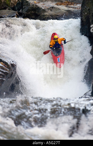 Extreme whitewater kayaker runs a class V waterfall with a 30-foot drop. Stock Photo