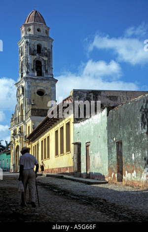 An elderly man walks up a street towards San Fransisco church in Trinidad Cuba Central America Stock Photo