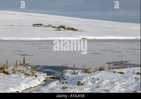 dh Kirbister Loch ORPHIR ORKNEY Frozen NOSW reservoir white snow burn farm and cottage Stock Photo