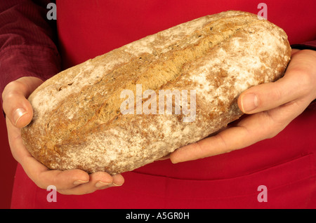 MAN HOLDING CRUSTY WHITE BREAD Stock Photo