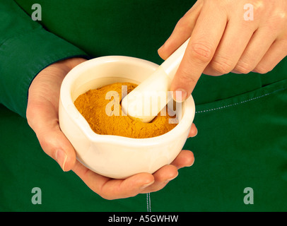 MAN GRINDING CURRY POWDER Stock Photo