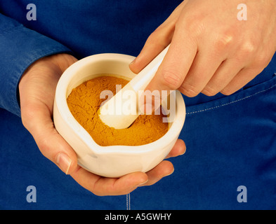 MAN GRINDING CURRY POWDER Stock Photo