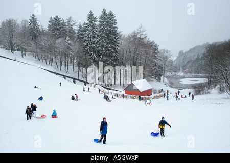 people tobogganning in St. Andreasberg in the Harz Mountains in Germany Stock Photo