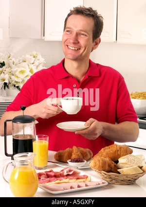 MAN HAVING BREAKFAST AND DRINKING COFFEE Stock Photo