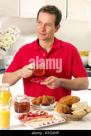 MAN HAVING BREAKFAST AND DRINKING TEA Stock Photo