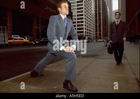 Businessman stretching on street Stock Photo