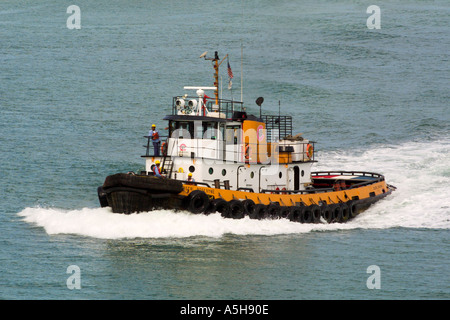 Tug boat sailing alongside cruise ship in Port of Tampa FL Stock Photo