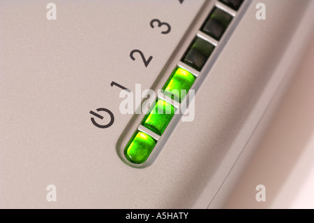 Closeup of a silver-colored ethernet hub with green LED indicators. Full description below. Stock Photo